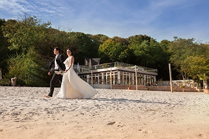 Hochzeitsinspiration im Seepavillon Brautpaar laufend am Strand